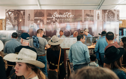 A wide shot of rodeo goers lining up at the Goode Co. BBQ concession at the NRG center.
