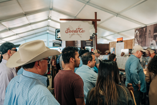 The Goode Co BBQ sign hanging at the food court while people are lining up to eat at the rodeo.